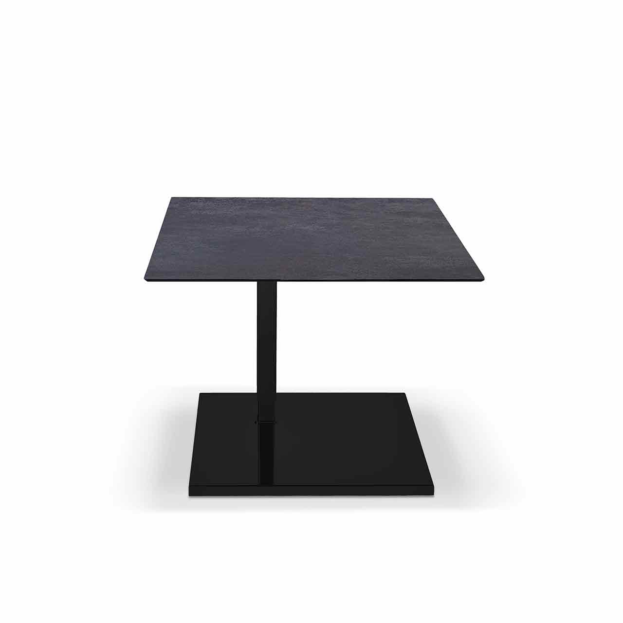 Beistelltisch mit quadratischer Tischplatte aus dunklem Keramik auf eckiger schwarzer Bodenplatte. Tisch ist runtergefahren.