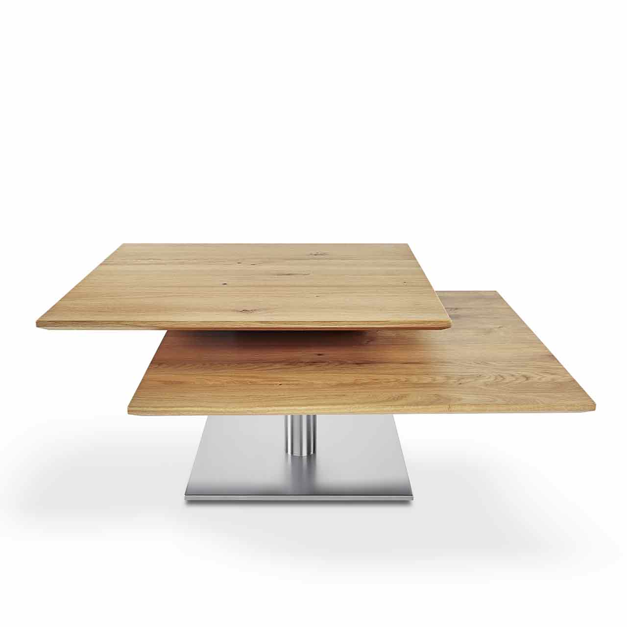 Ronald Schmitt – Couchtisch Evita H 509 | Tischplatte Wildeiche, Bodenplatte Edelstahl geschliffen Couchtisch mit zwei beweglichen Tischplatten aus hellem Holz. Die Tischplatten sind etas auseinandergedreht. Der Sockel ist aus Edelstahl.